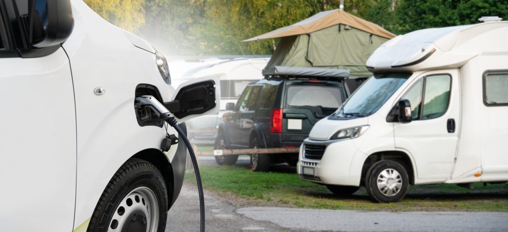 Electric camper on a background of a campsite